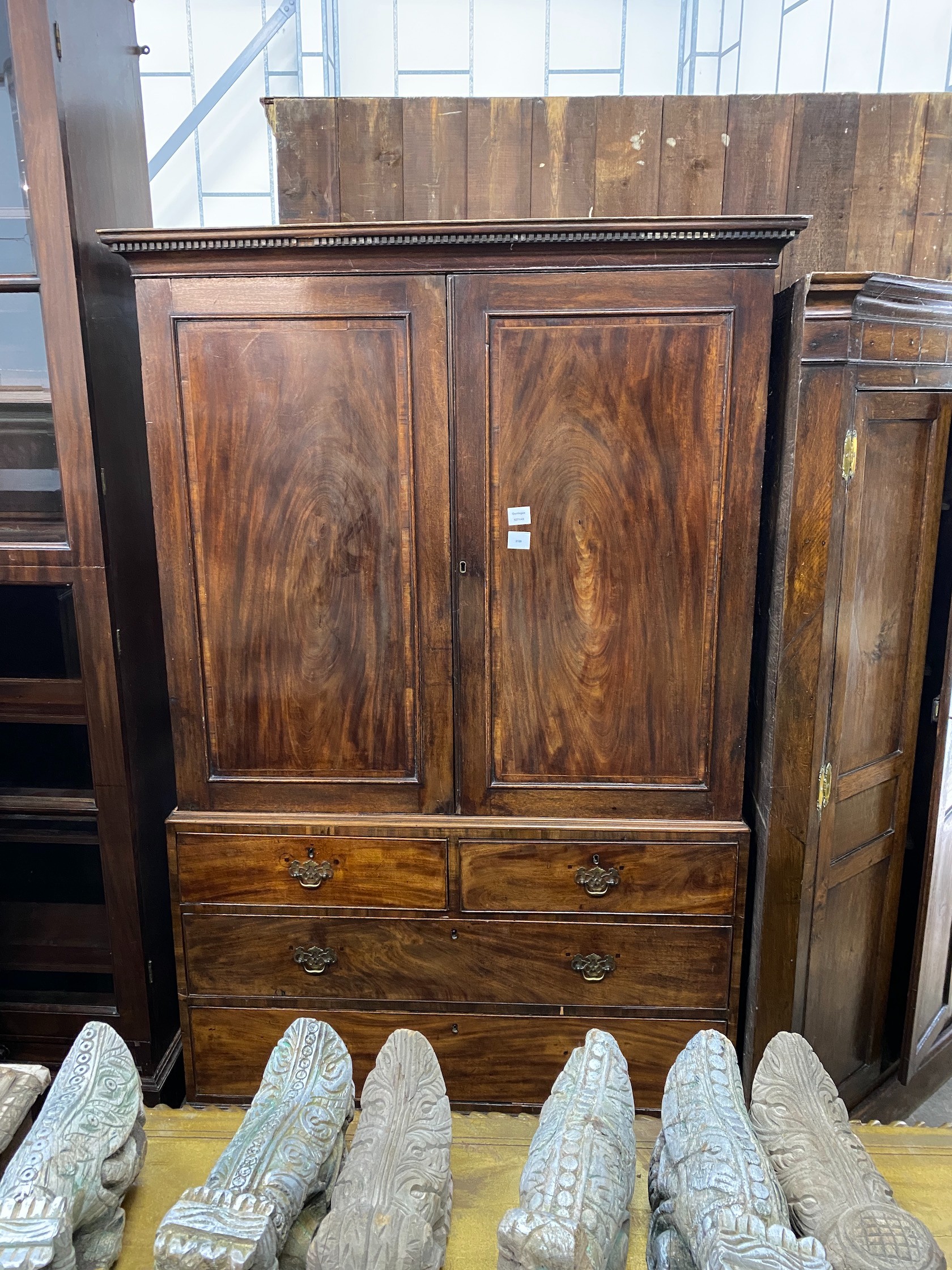 A George III mahogany linen press, converted to a hanging wardrobe, width 116cm, depth 55cm, height 195cm